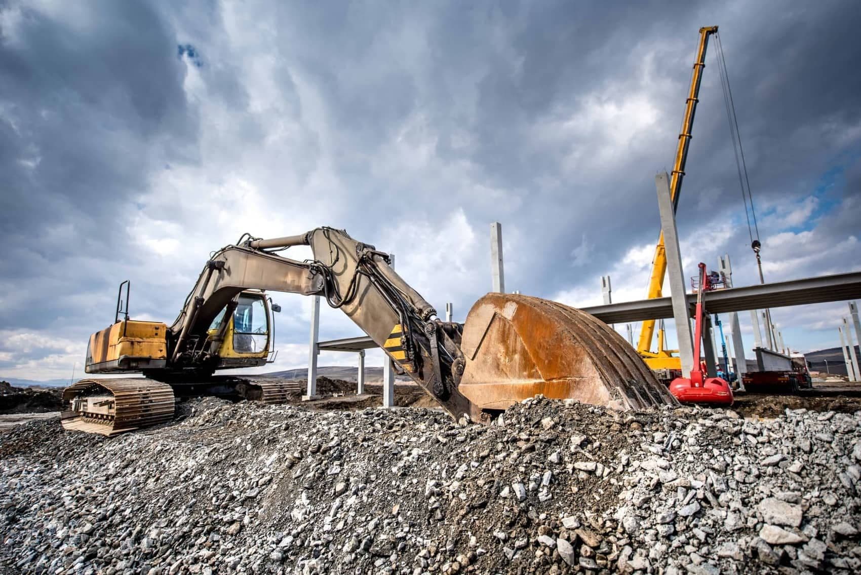Excavator working on a construction site, where ISO 45001 safety systems apply