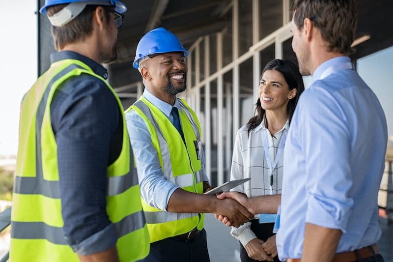 Manager and engineer shaking hands on a construction site