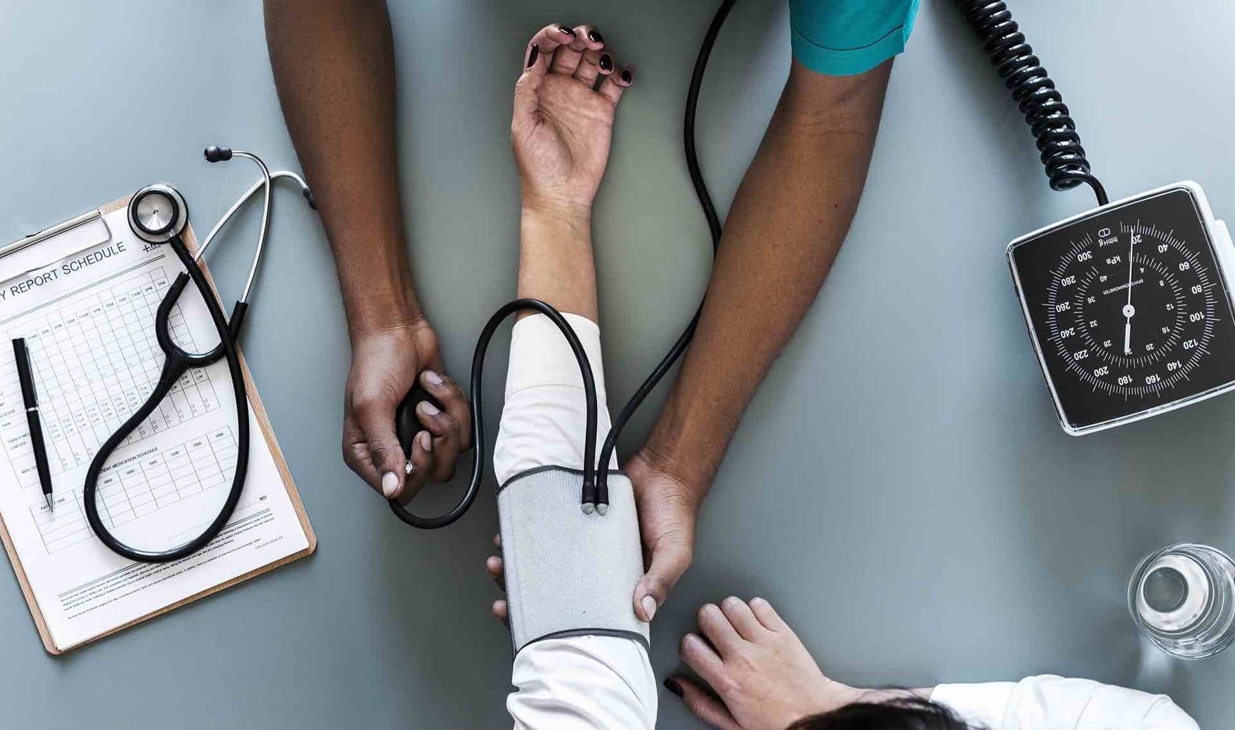 Occupational health nurse taking an employee's blood pressure during a workplace medical