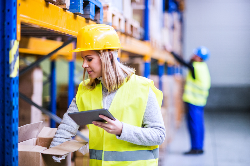 Woman warehouse worker with tablet.